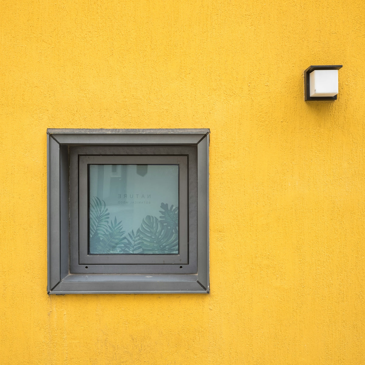 black wooden window frame on yellow wall