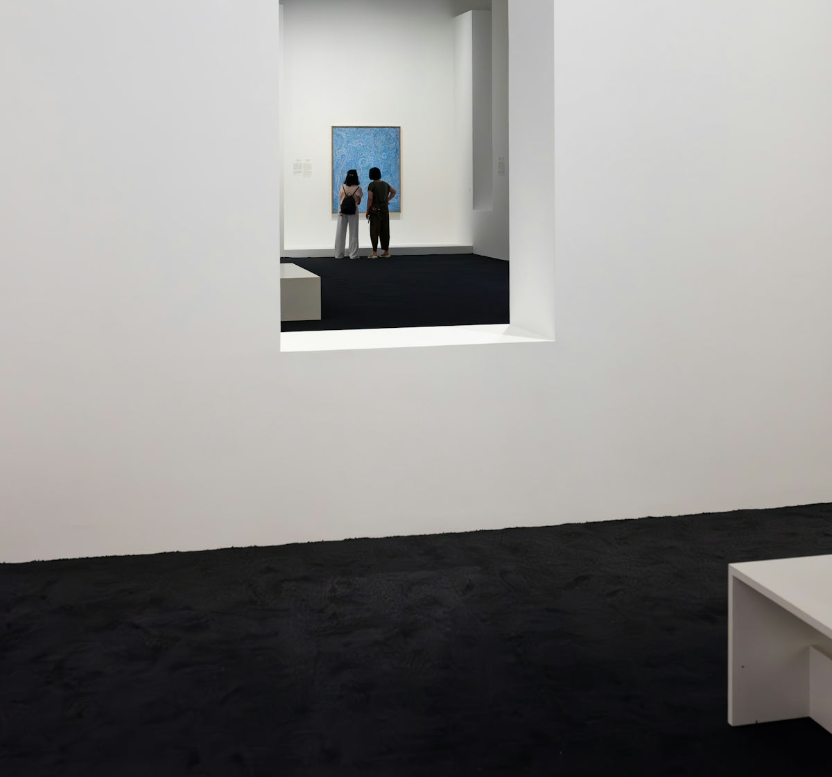 People observe art in a modern gallery.