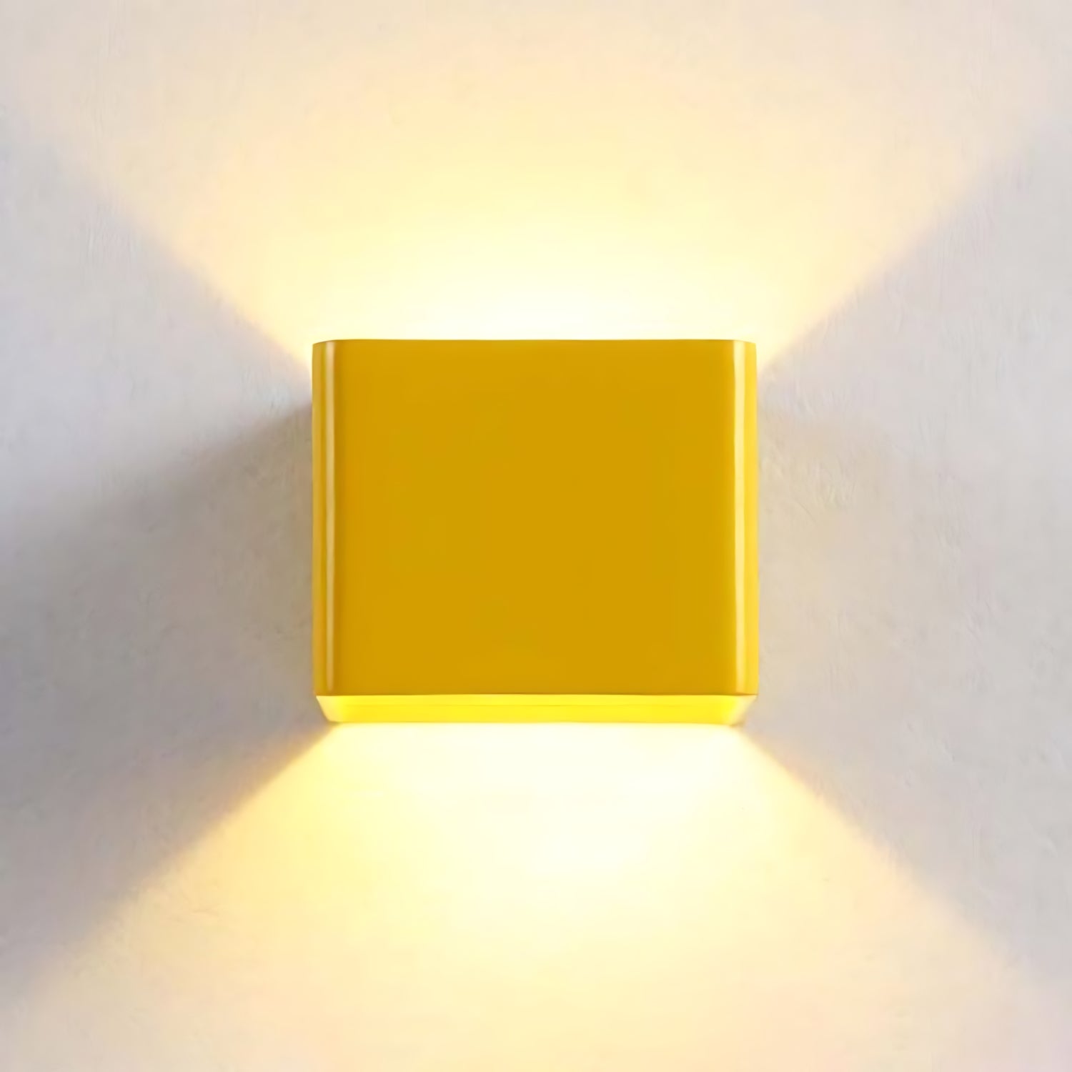 A modern square wall lamp with a sleek design, casting a soft glow on the wall in black, white, and green colors.