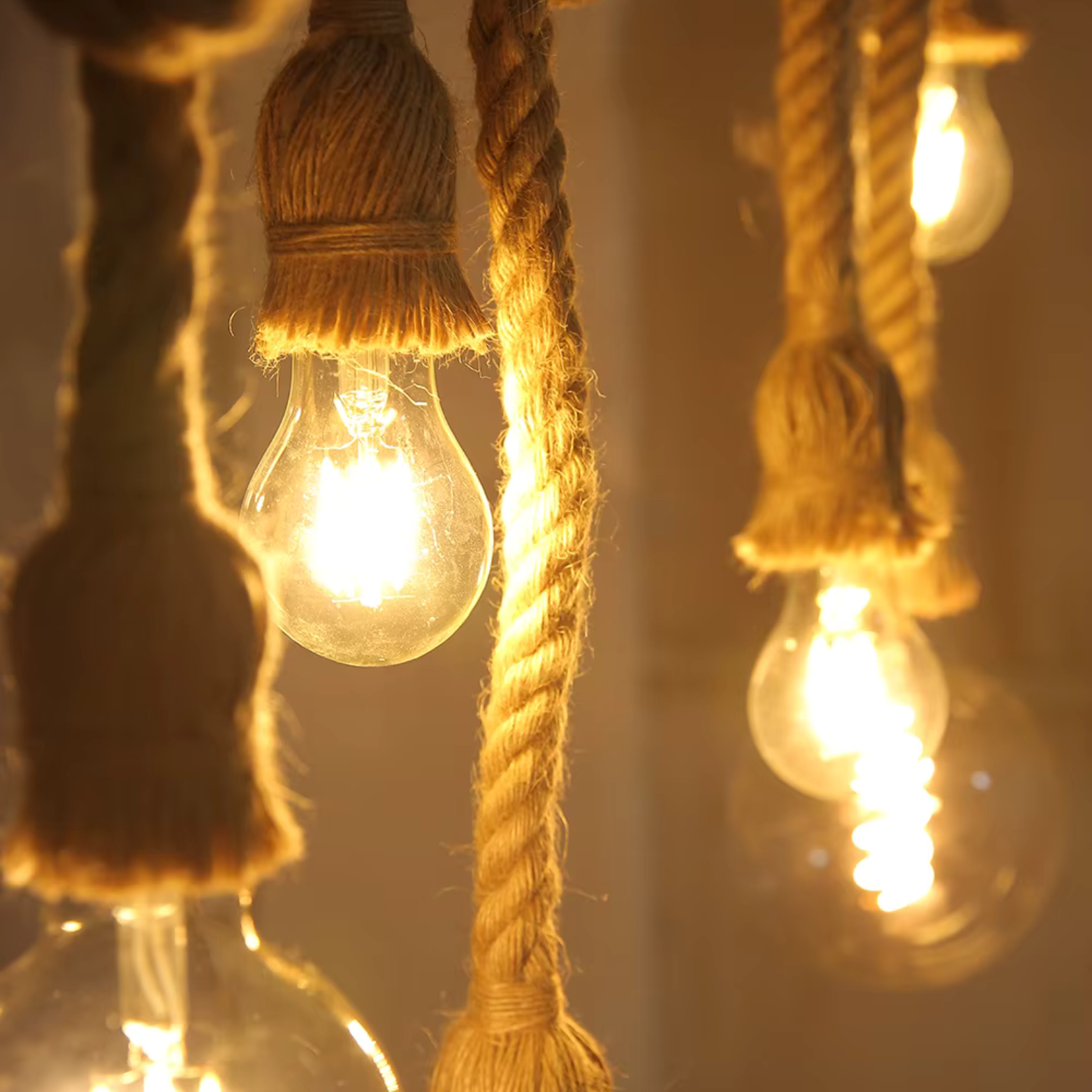 String of light bulbs hanging by rope with a warm glow