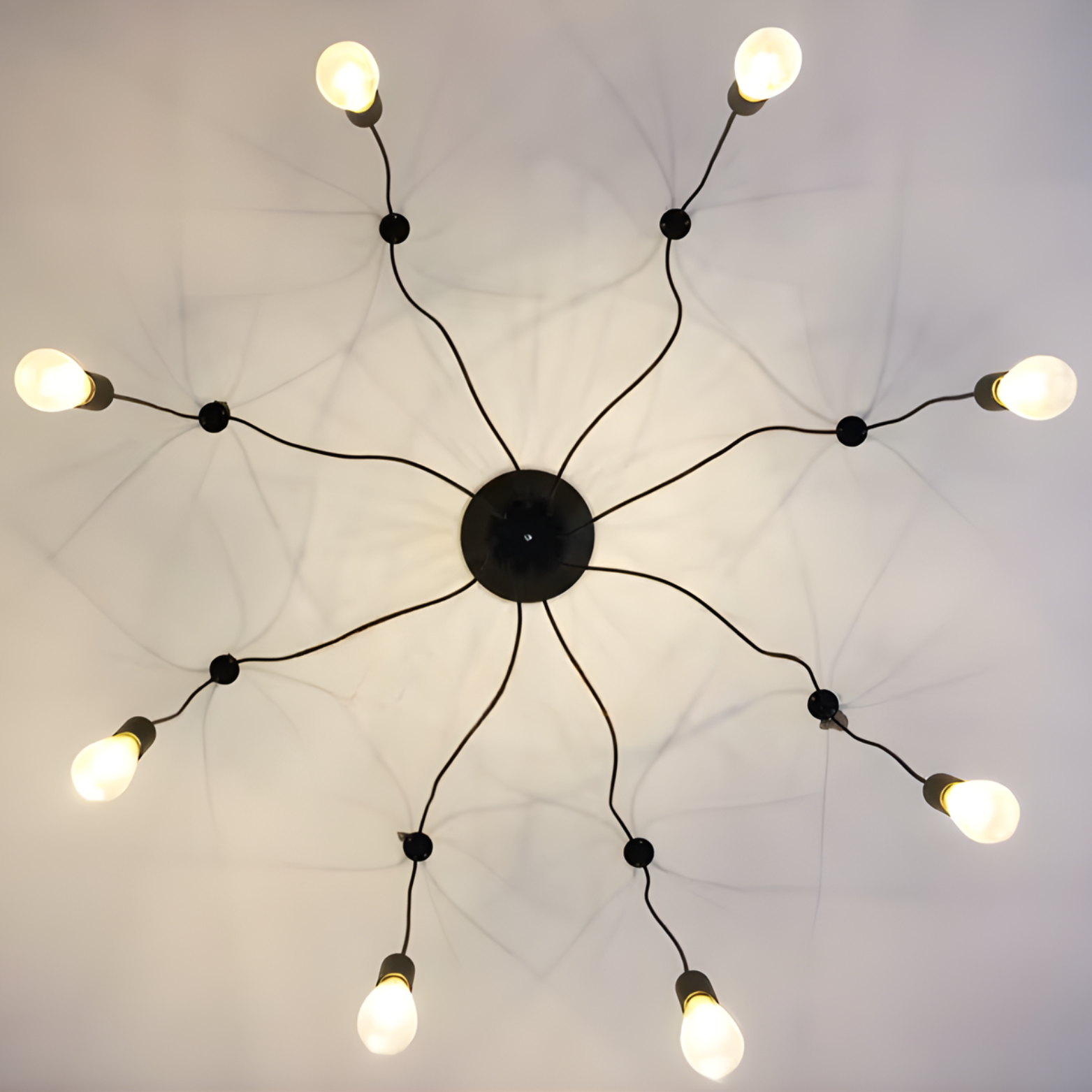 Modern chandelier with multiple light bulbs on a white ceiling