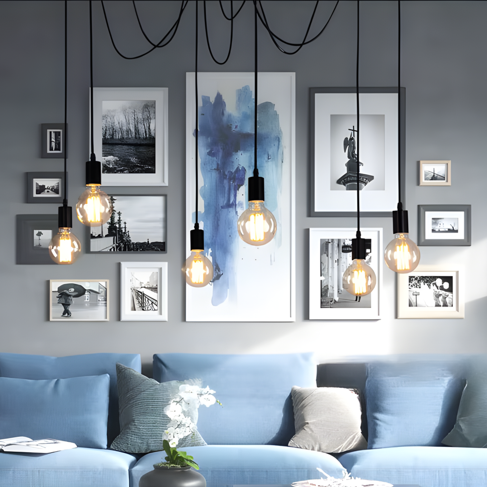 Living room with blue sofa, framed pictures, and hanging light bulbs.