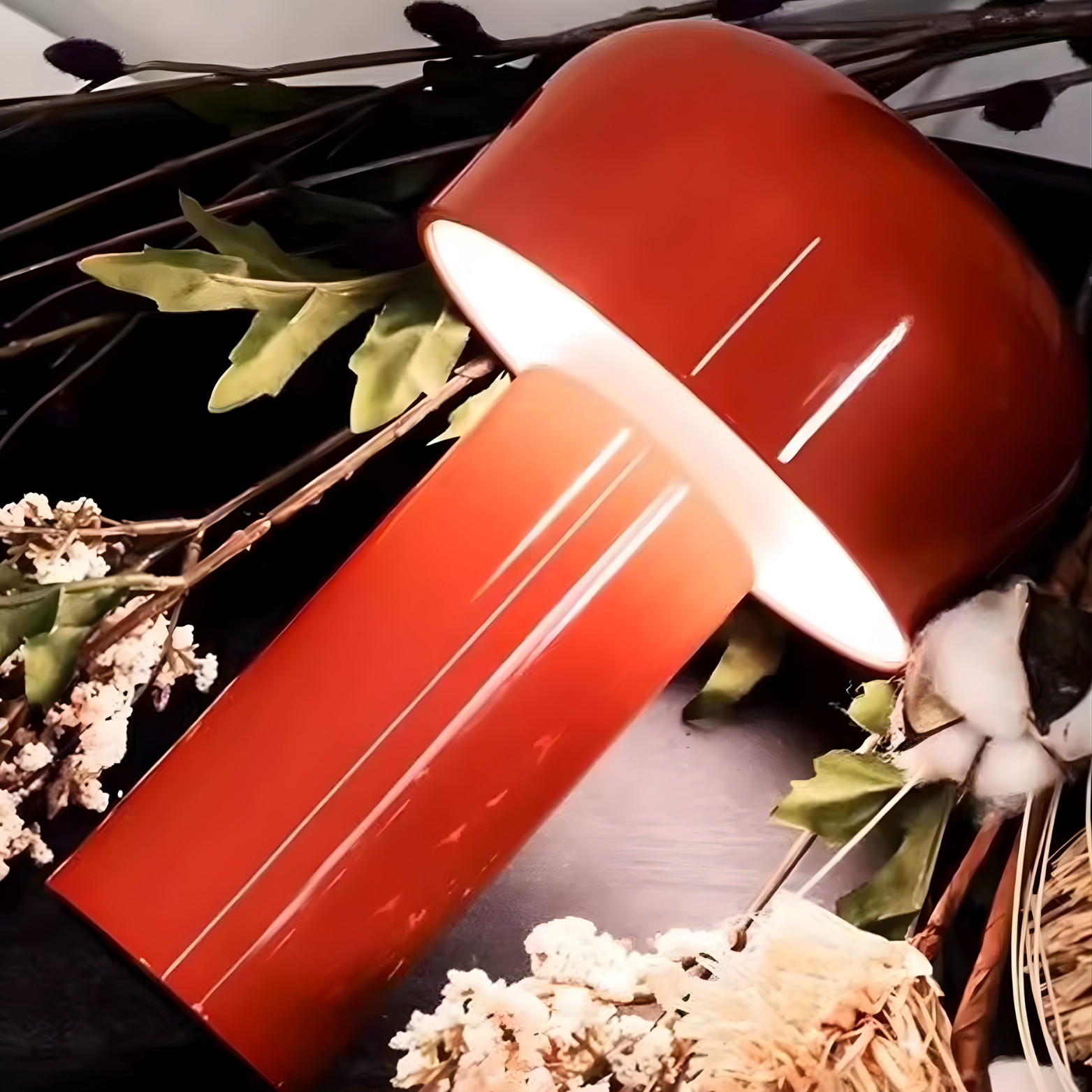 Red lampshade on a dark surface with decorative plants