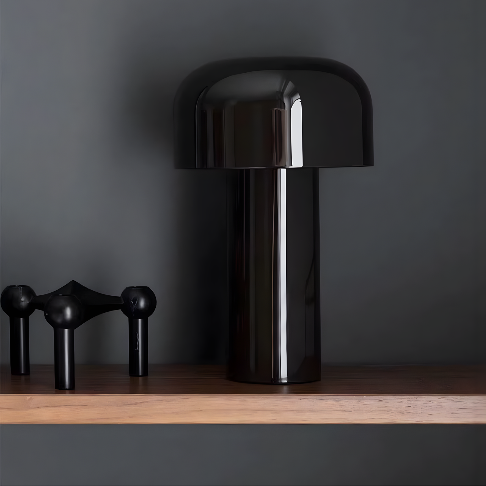 Black table lamp on a wooden surface with a dark gray background