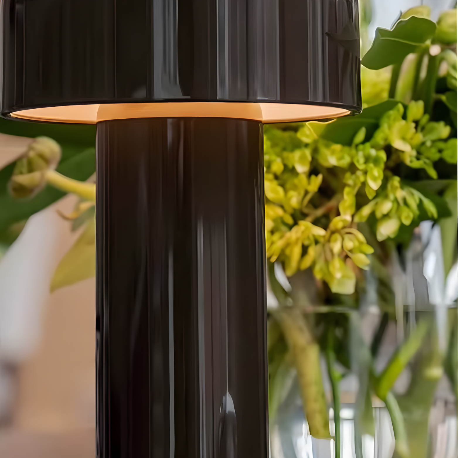 Black outdoor lamp with a blurred green plant background