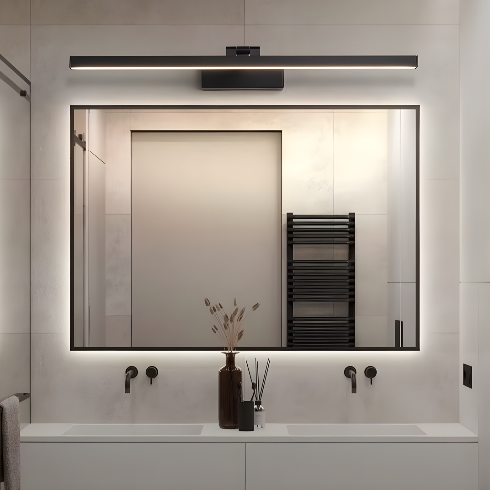 Modern bathroom with a large mirror, light fixture, and decorative elements.
