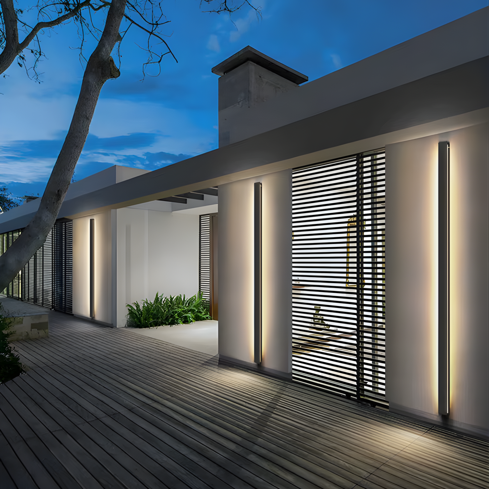 Modern outdoor patio area with illuminated walls and deck at night