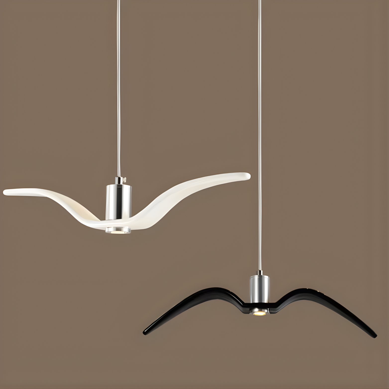 Two modern pendant lights with white and black wing-like design on a brown background
