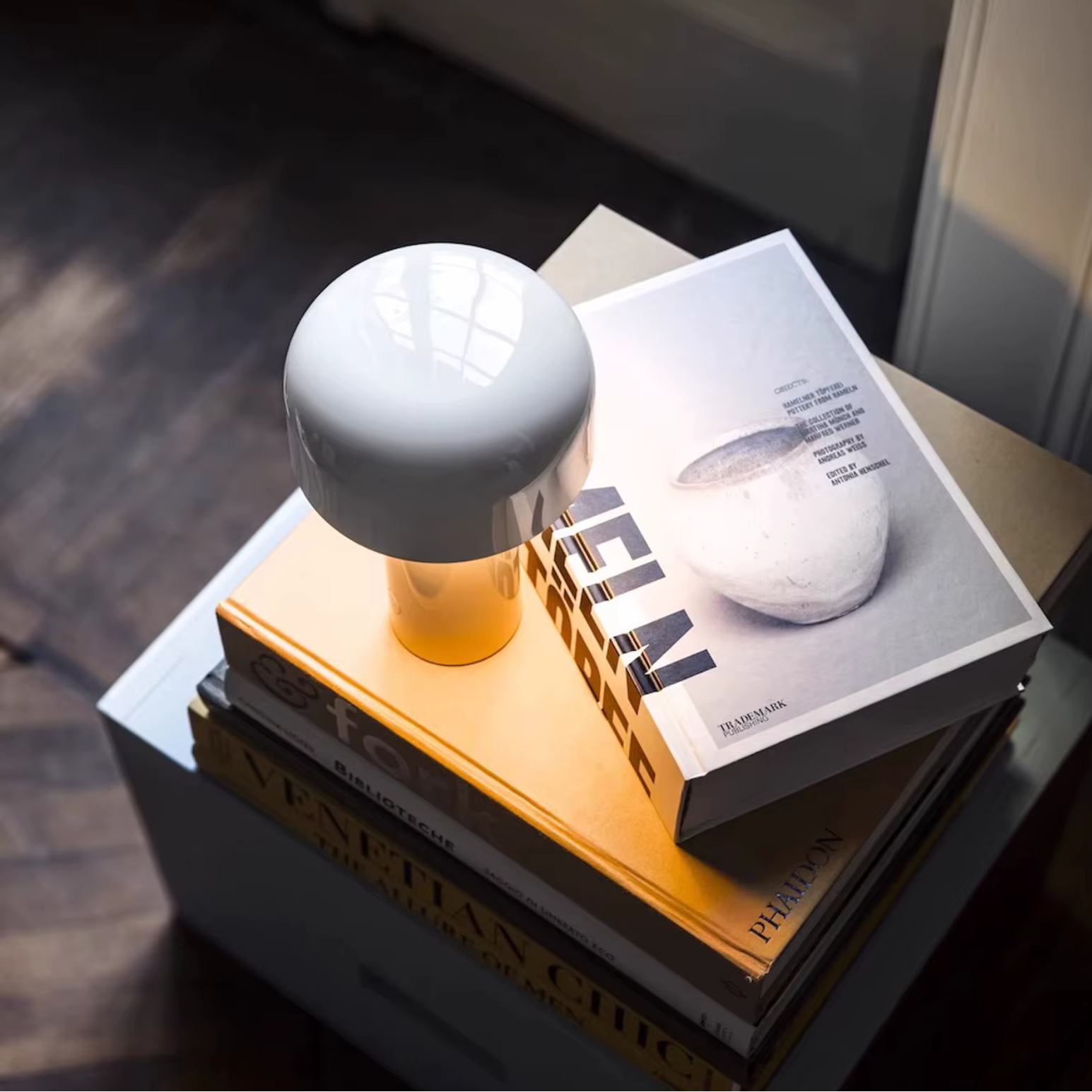 White spherical object on a stack of books with a magazine underneath