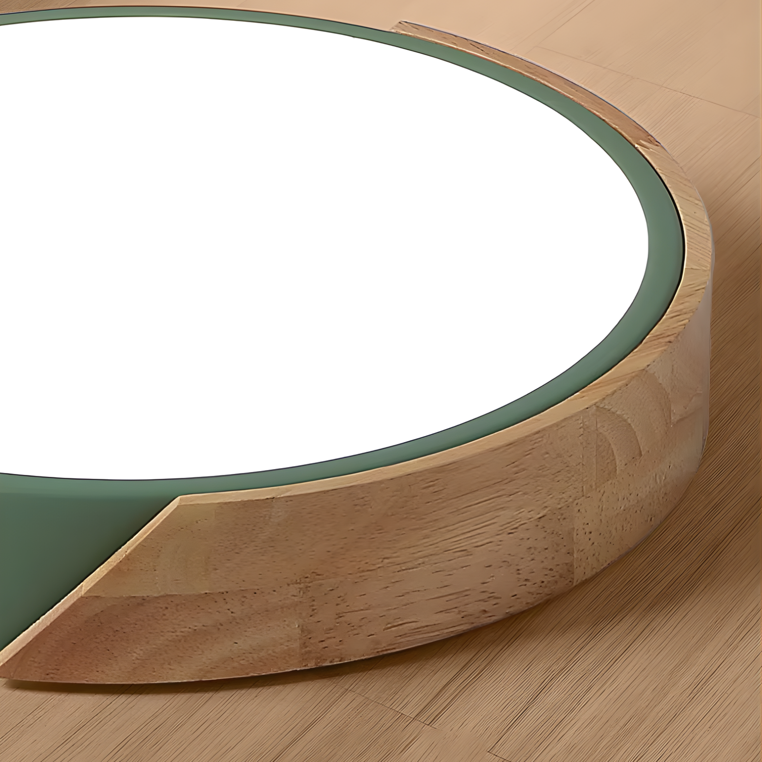 Round wooden table with a white top and green rim on a wooden floor.
