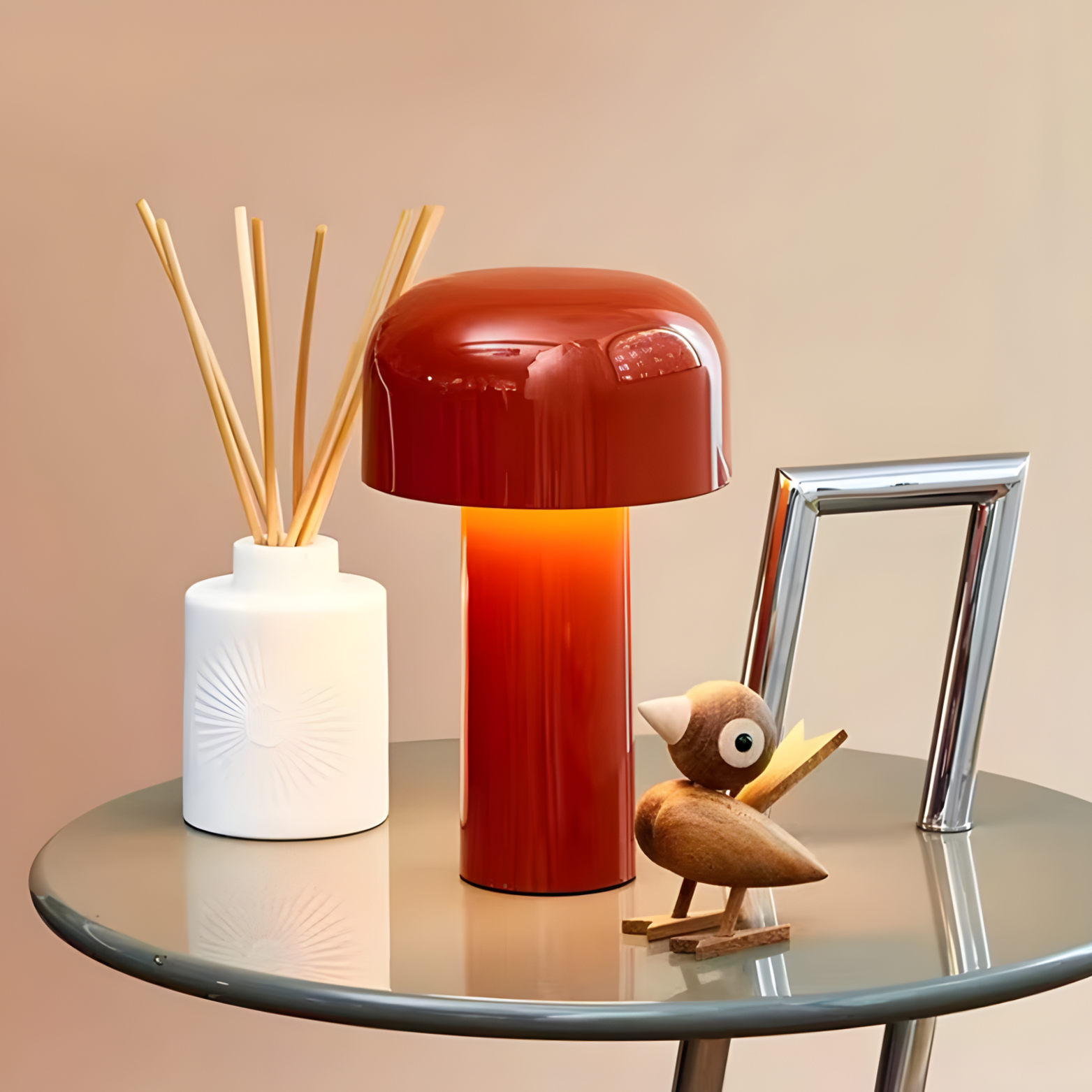 Decorative items including a red lamp, diffuser, and small owl figure on a glass table.