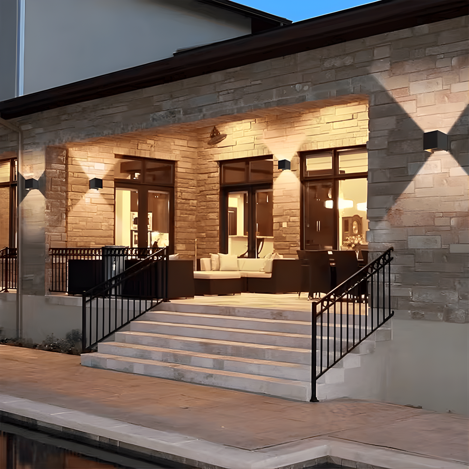 Modern building exterior with stone facade, glass doors, and outdoor seating area.