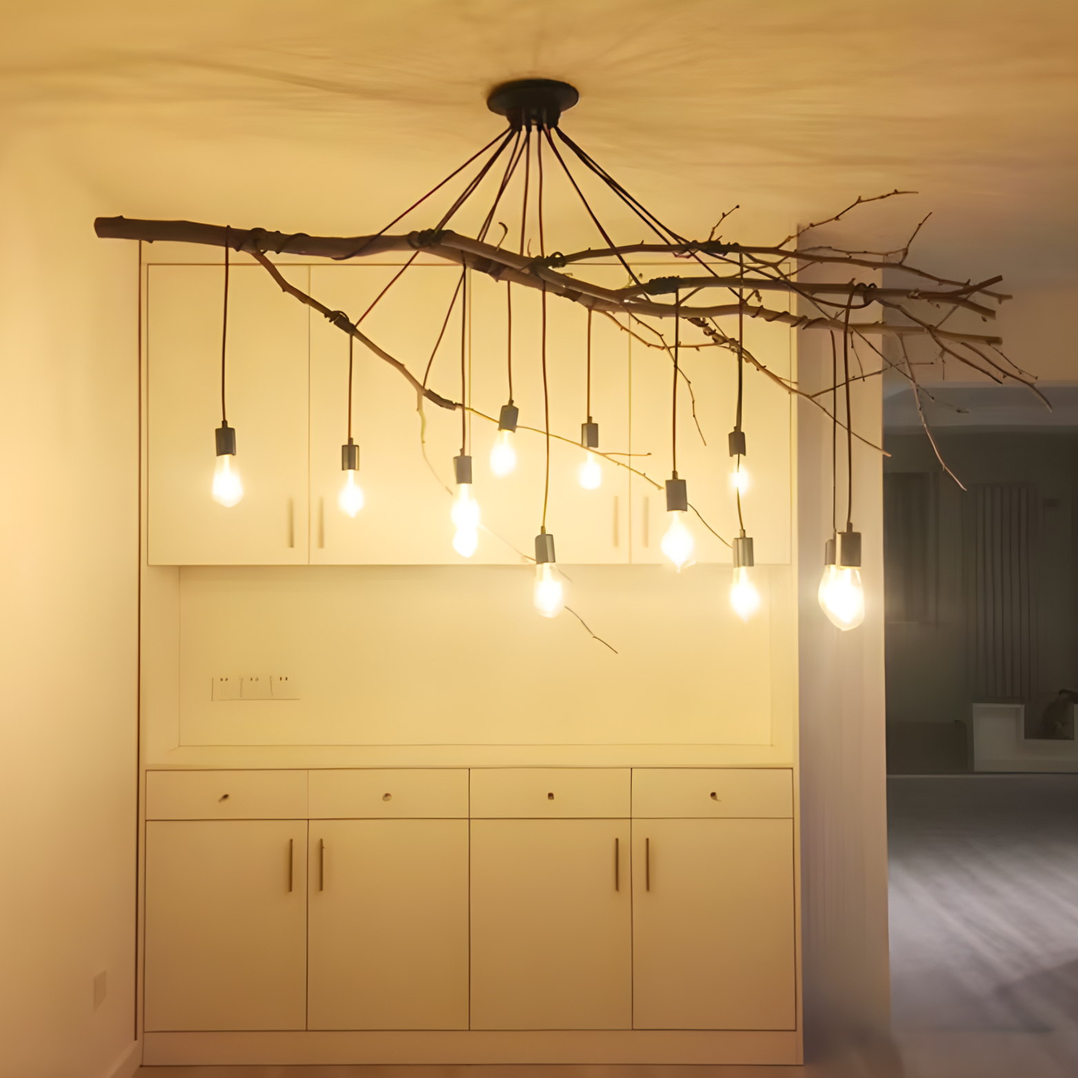 Chandelier made of branches with hanging light bulbs in a room setting.