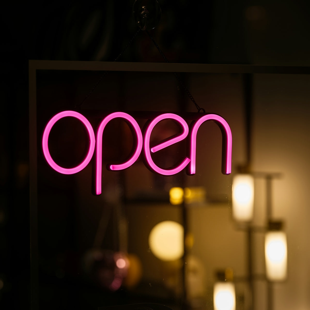 A neon sign that says open in a dark room