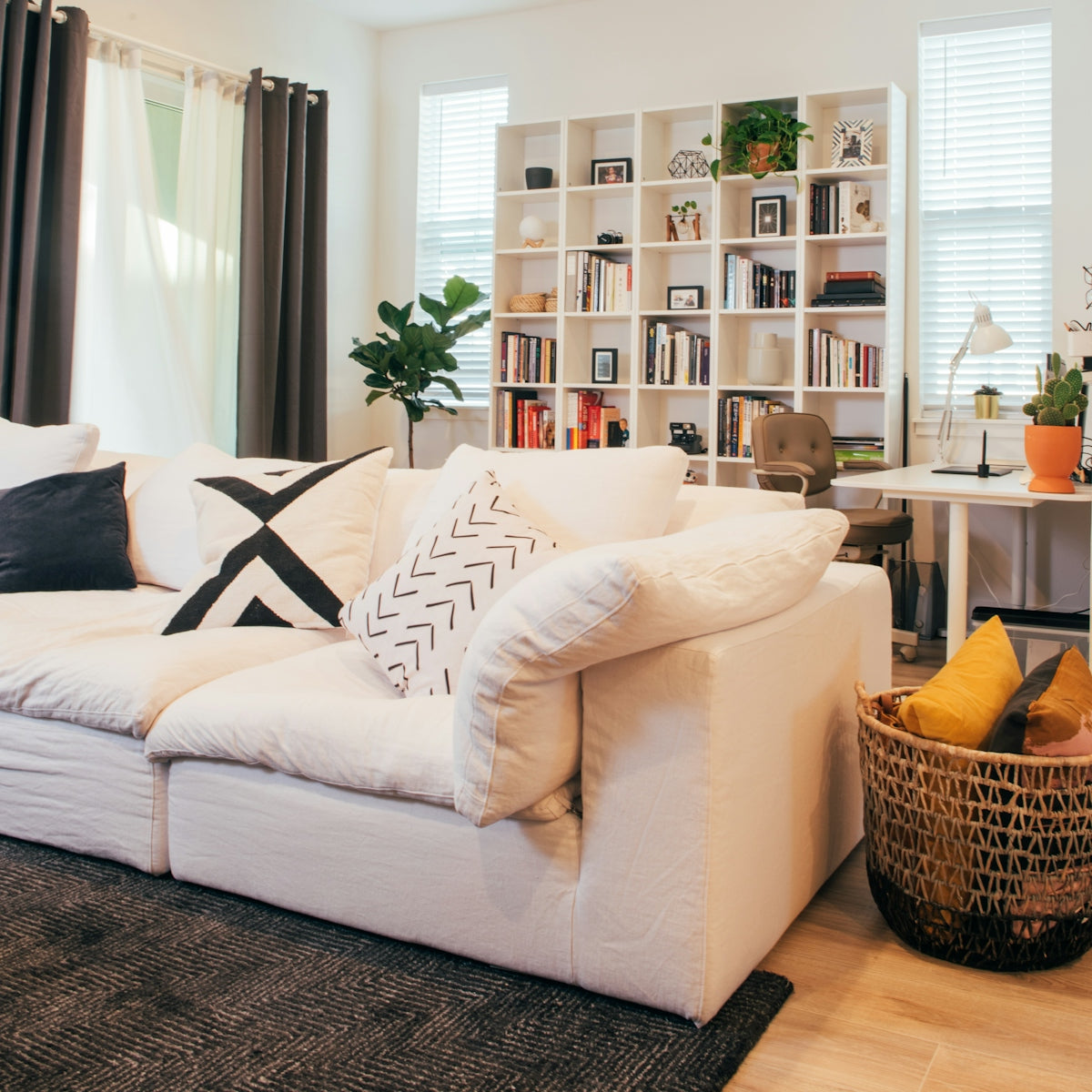 Cozy living room with large white sofa and bookshelf