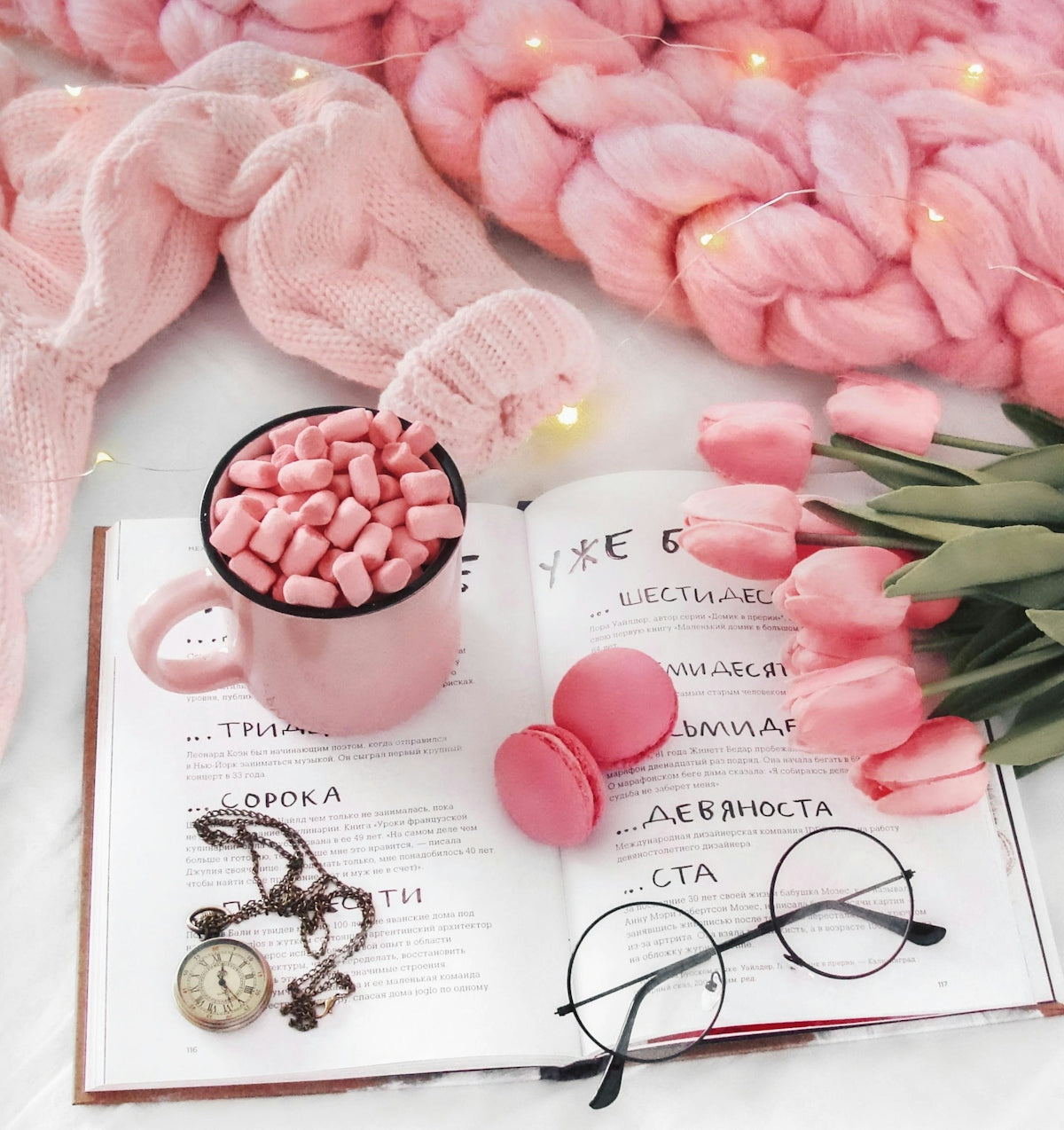 Cozy scene with book, hot chocolate, macarons, and tulips