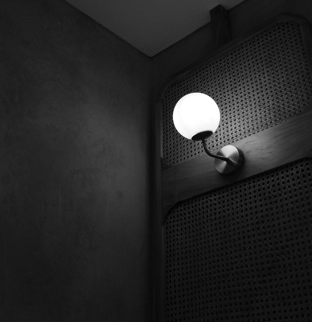 A modern wall lamp illuminates a textured surface.