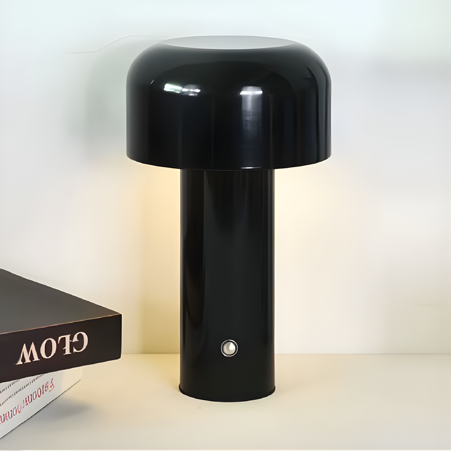 Black table lamp on a white surface with a book in the background