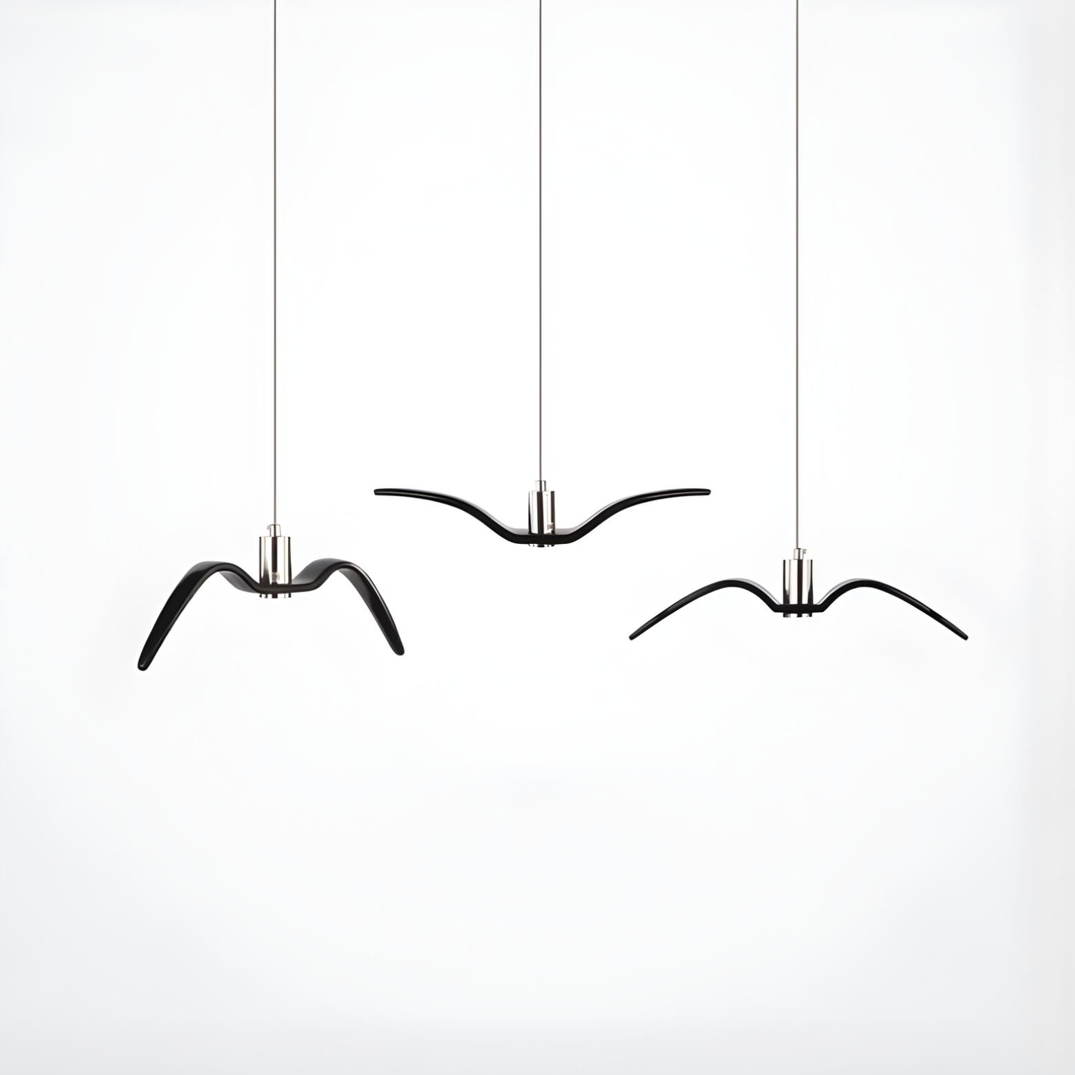 Three black bird-shaped candle holders hanging against a white background