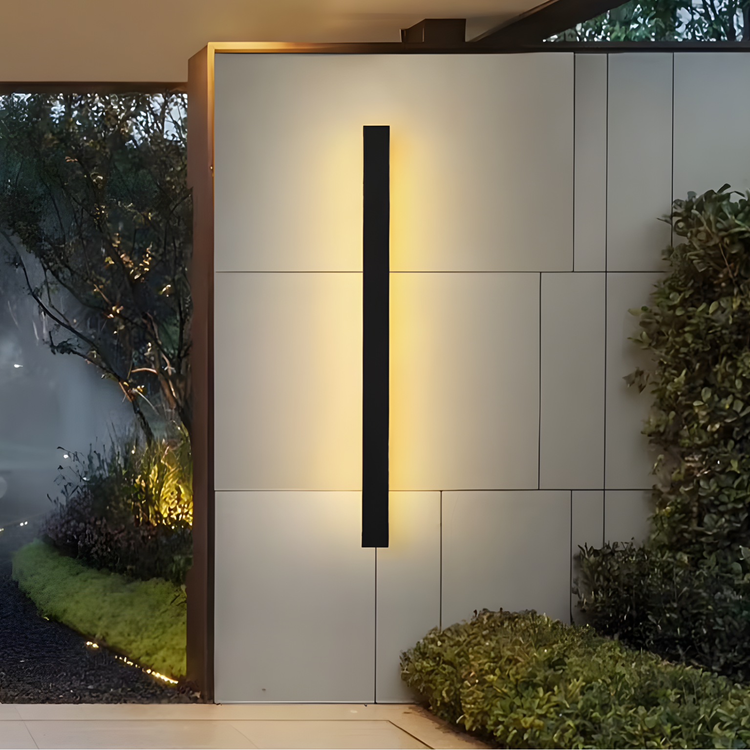 Modern outdoor wall light fixture on a tiled wall with greenery around