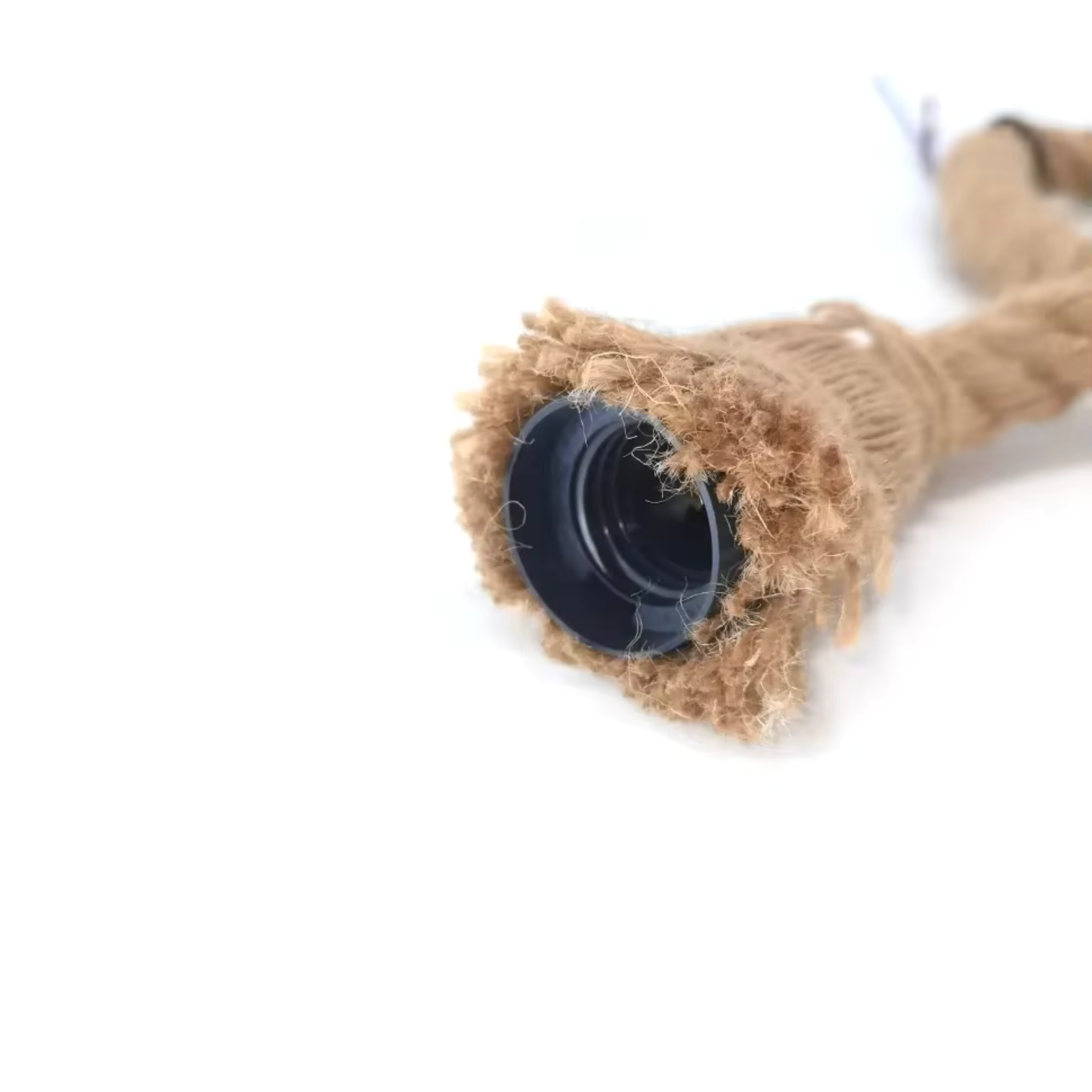 Close-up of a coiled rope with a black end cap on a white background