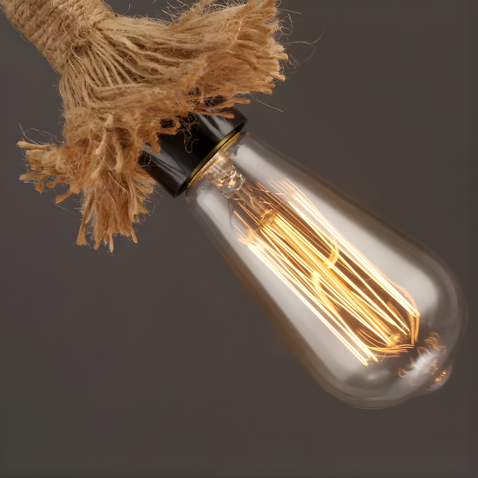 Edison-style light bulb with visible filament on a dark background