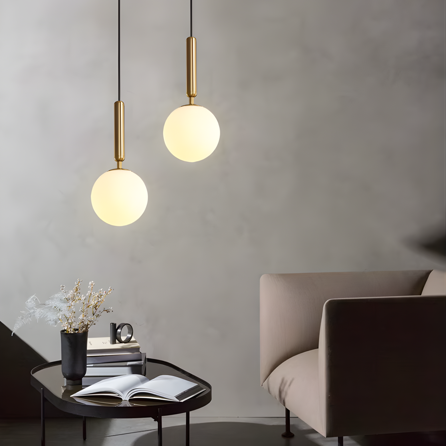 Modern living room with two pendant lights, a table with books and a mug, and a sofa.