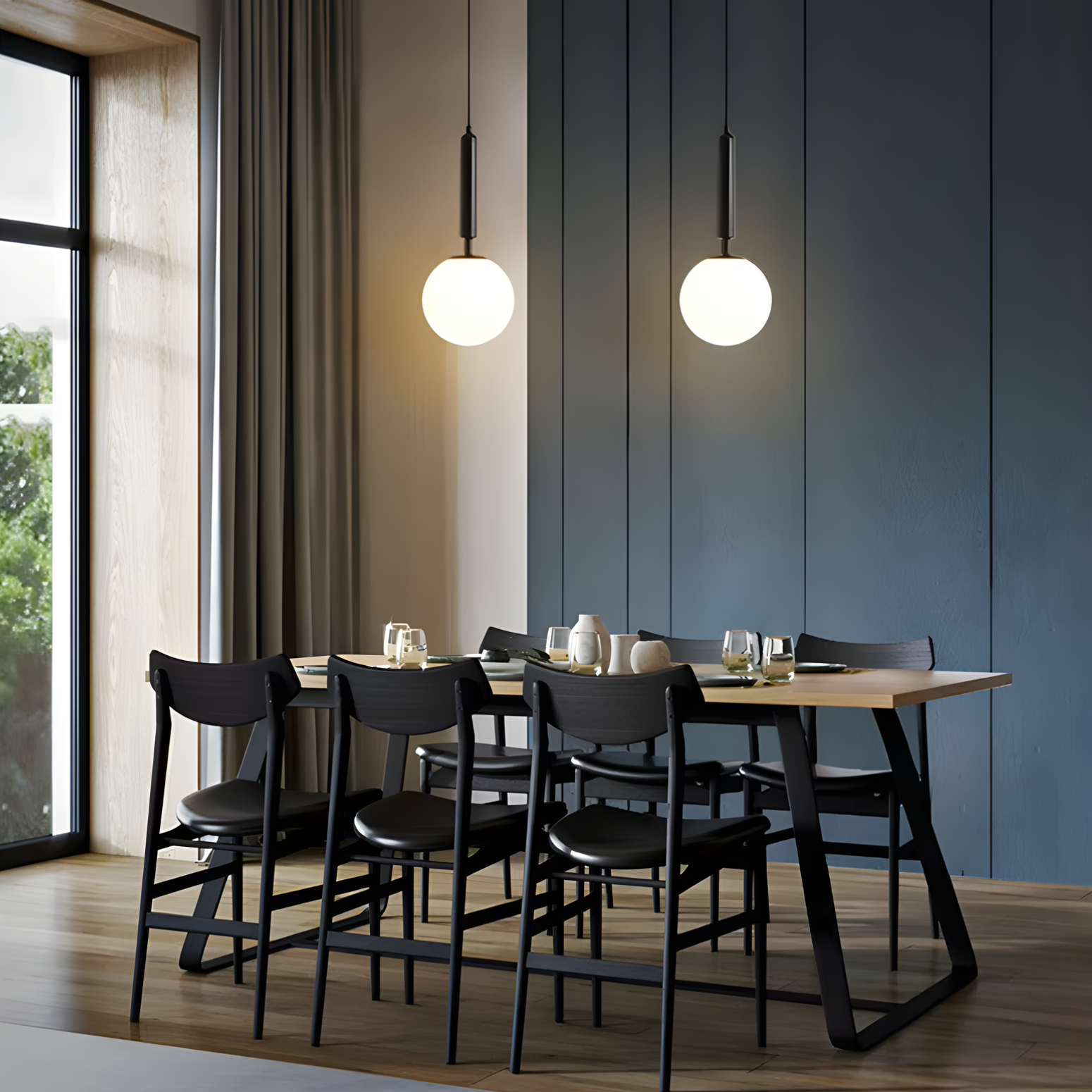 Dining area with a wooden table and black chairs under two pendant lights.