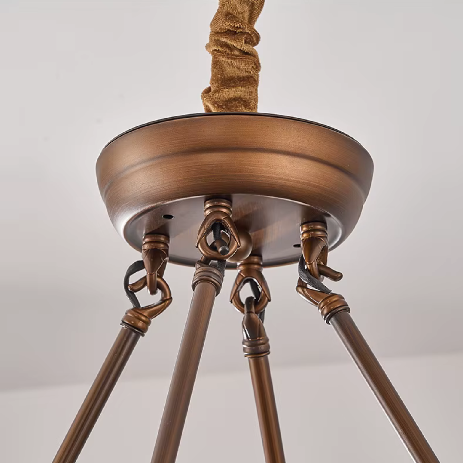 Bronze ceiling light fixture with three arms on a white background