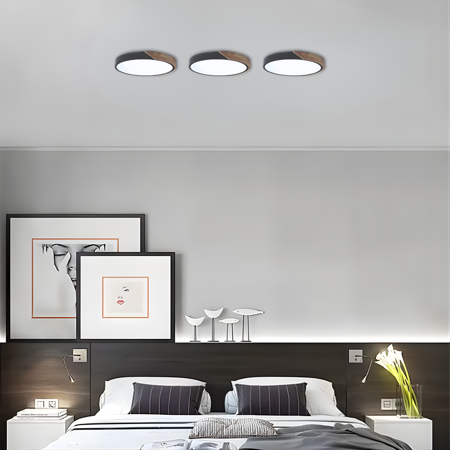 Modern bedroom with three ceiling lights, framed art, and a bed.