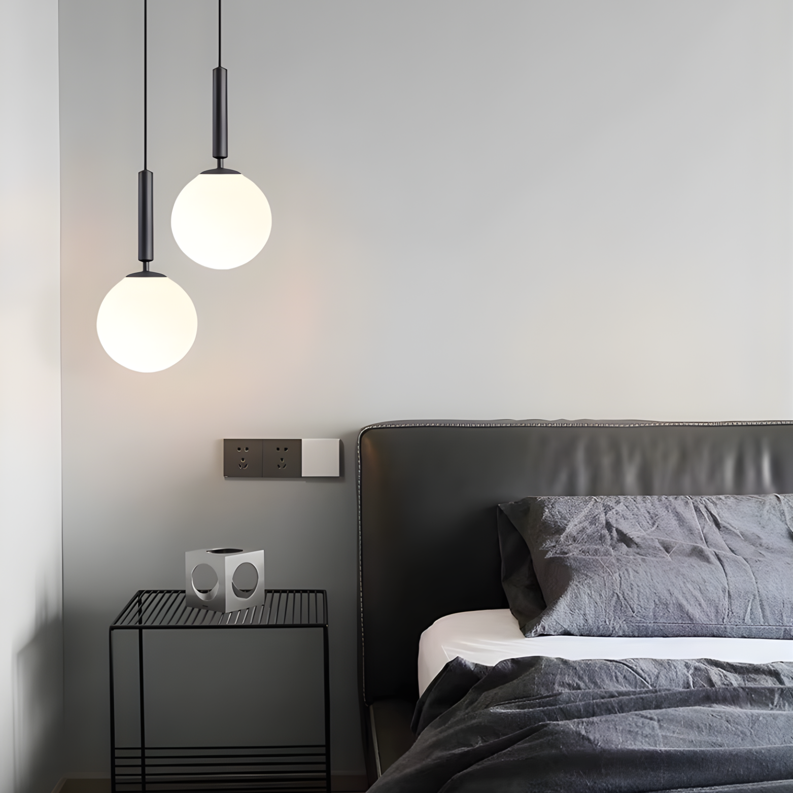 Modern bedroom with a bed, nightstand, and pendant lights.