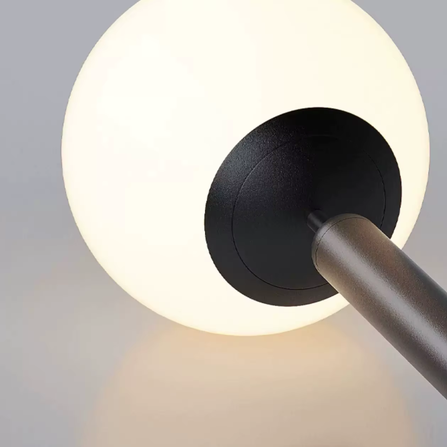 Modern wall lamp with a black fixture and white glass shade on a gray background