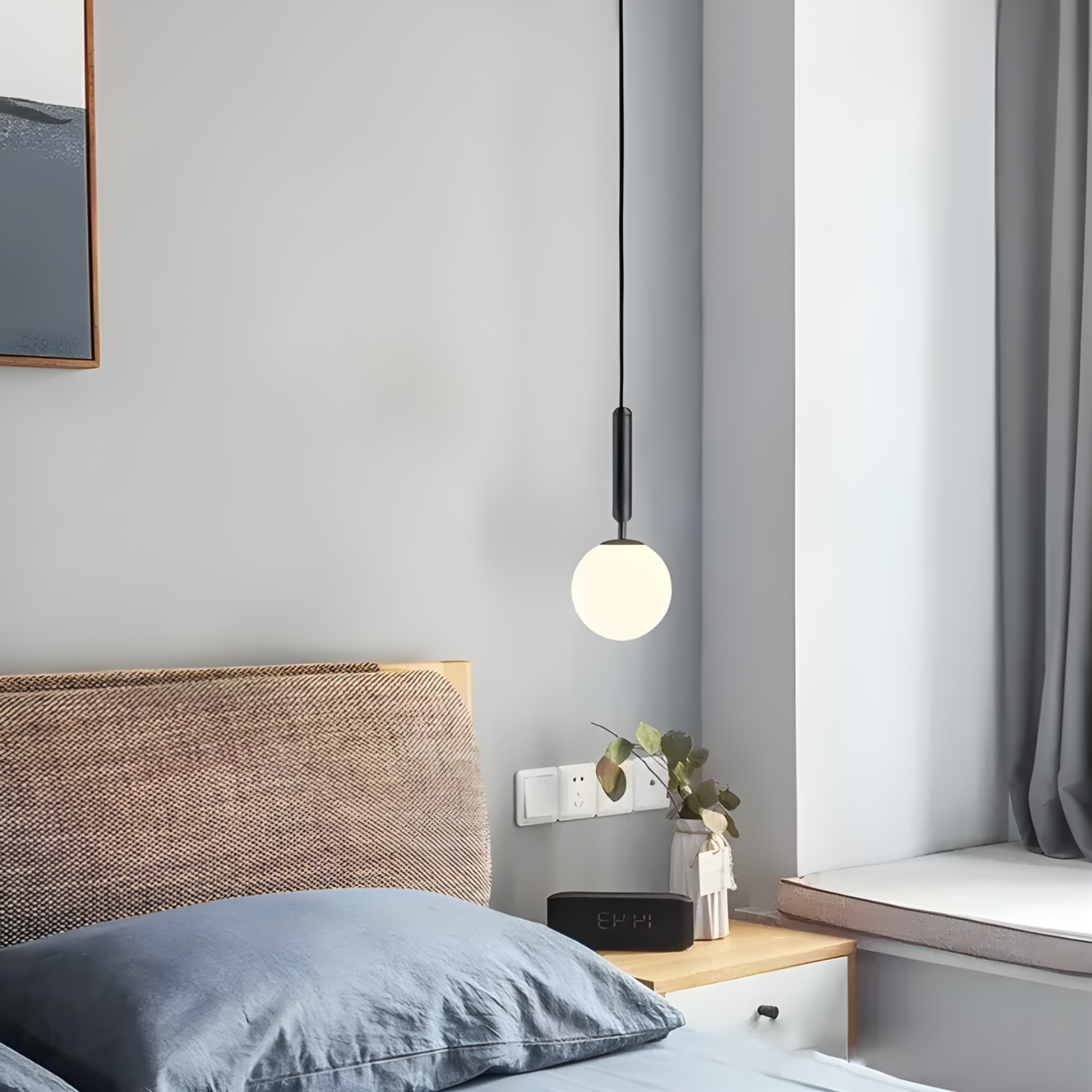 Modern bedroom with a bed, nightstand, and pendant light.