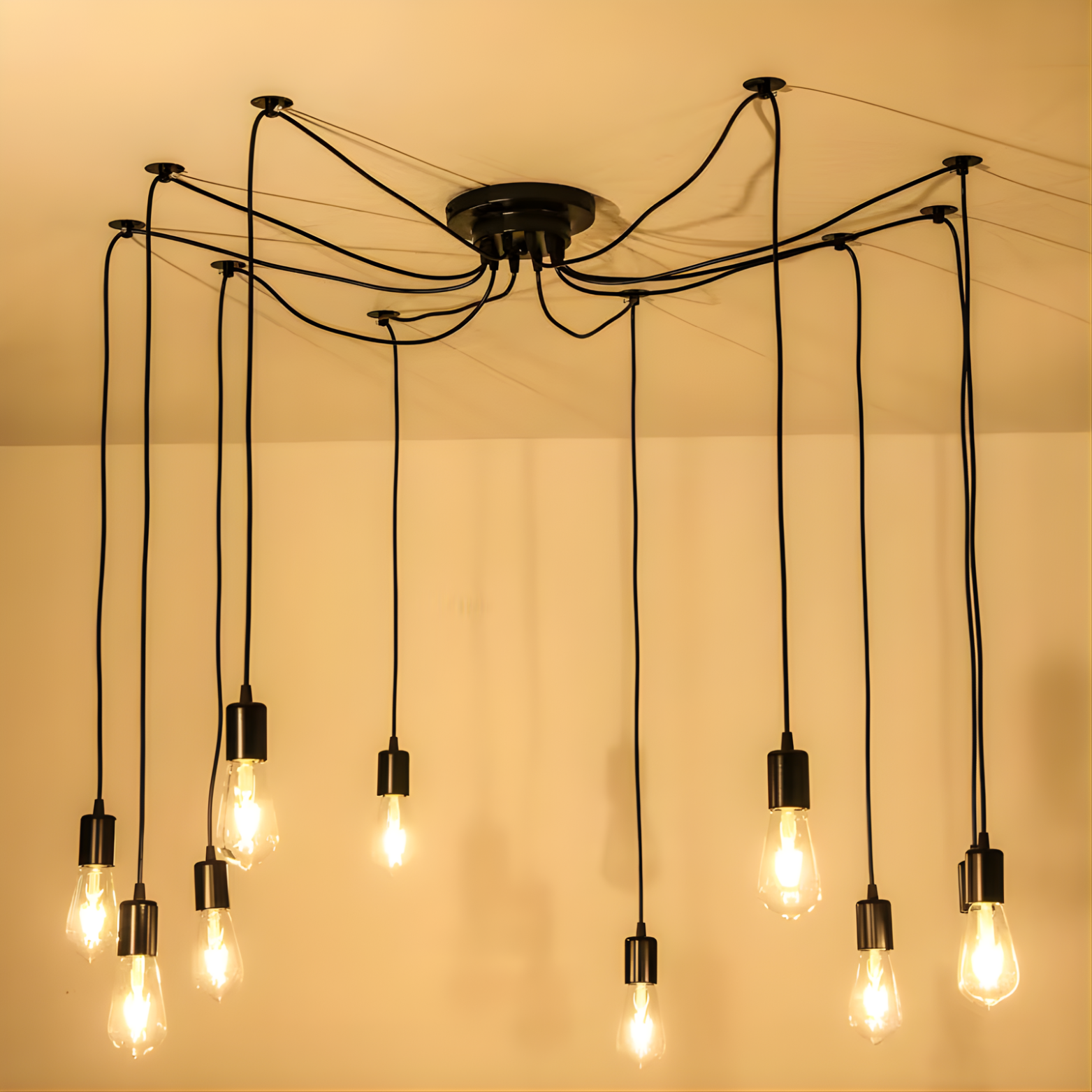 Modern chandelier with multiple hanging light bulbs against a plain background