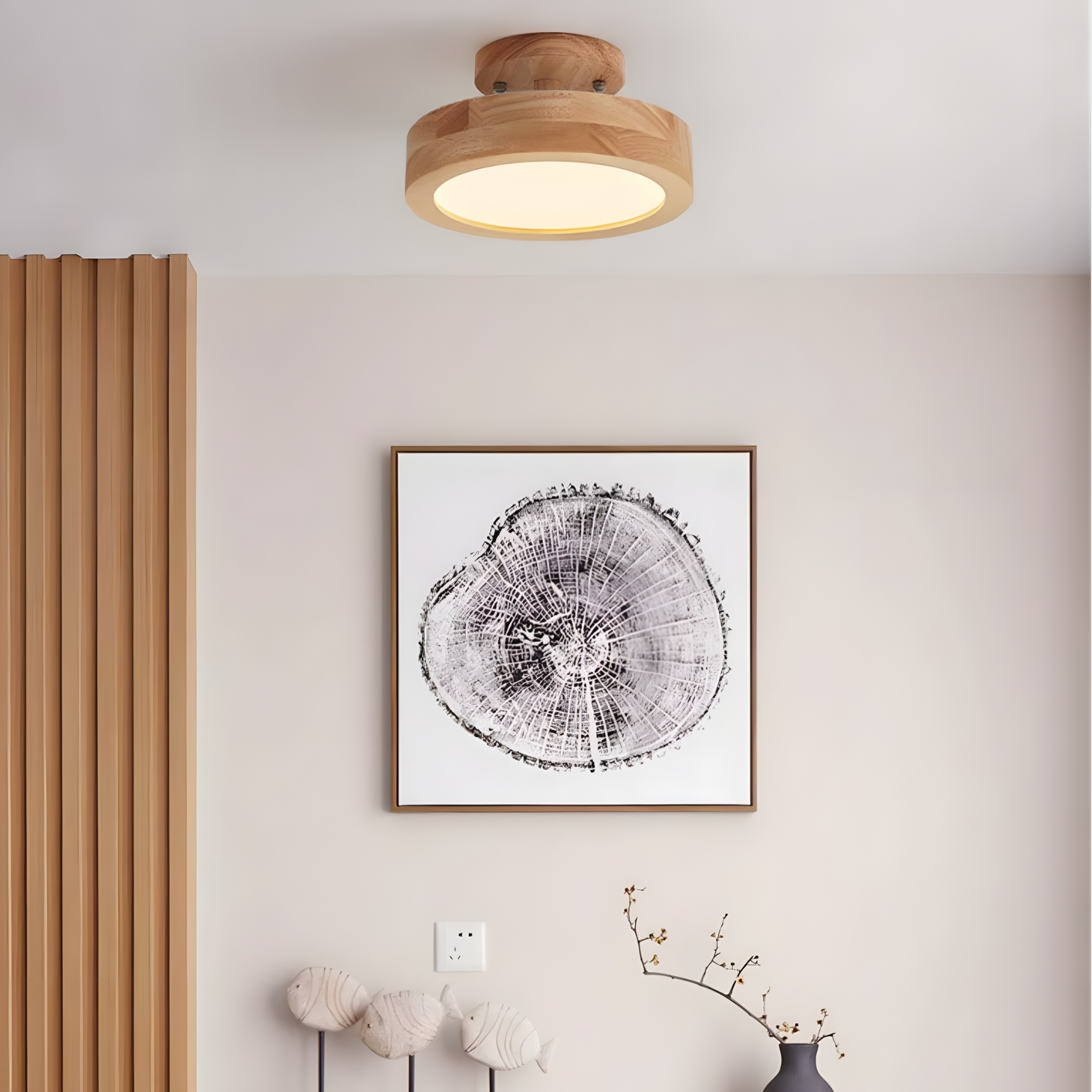 Wooden ceiling light fixture above a framed tree ring print on a wall with decorative elements.