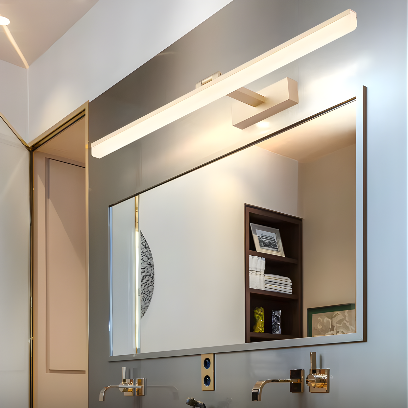 Bathroom mirror with modern lighting fixture reflecting a neatly arranged bathroom.