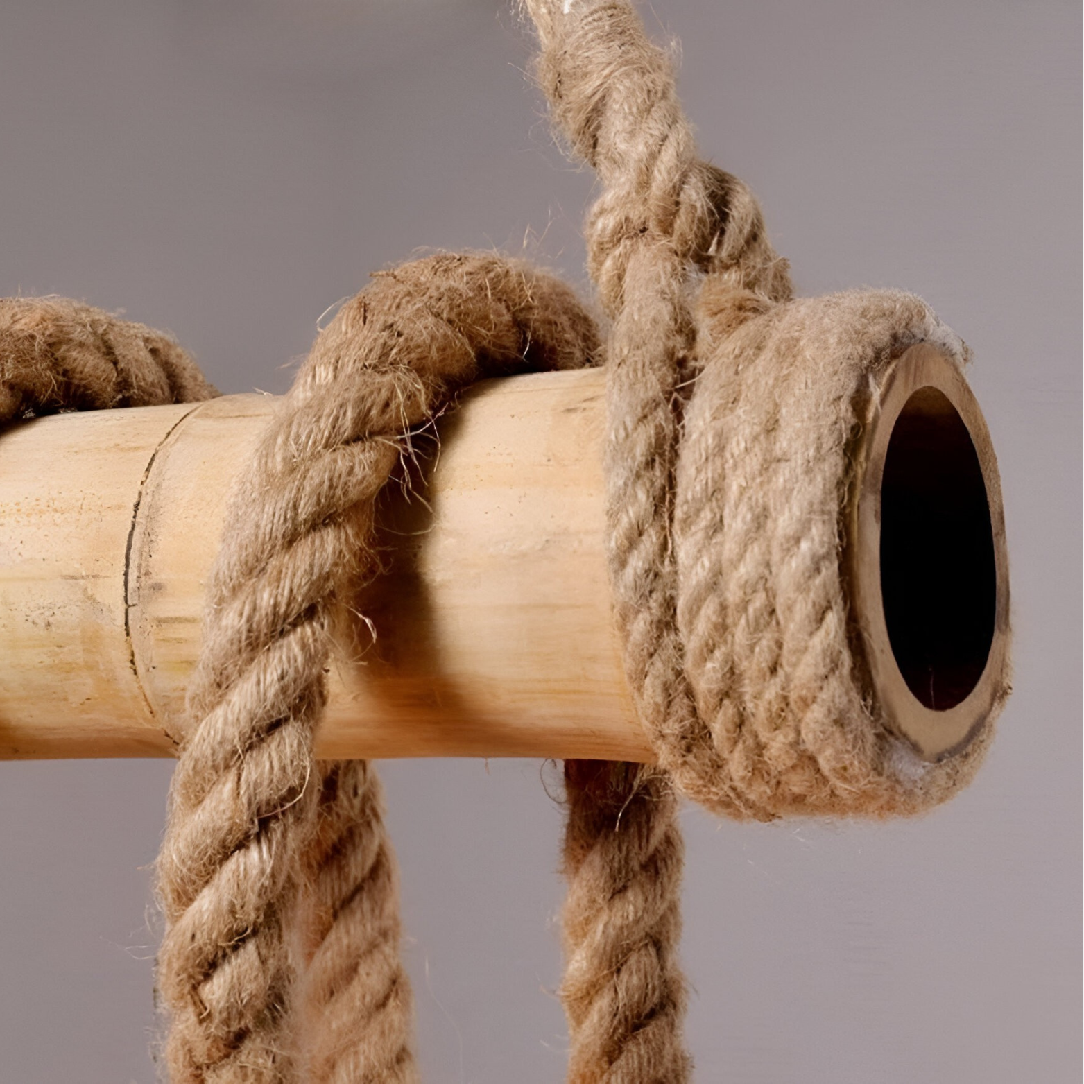 Pendant light Close-up of a wooden dowel with rope wrapped around it on a gray background