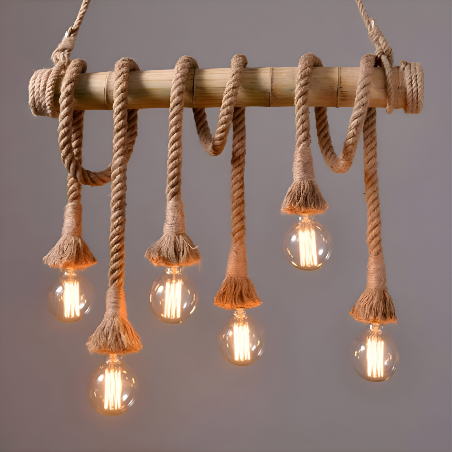 Chandelier with wooden rod and rope accents featuring lit bulbs on a gray background