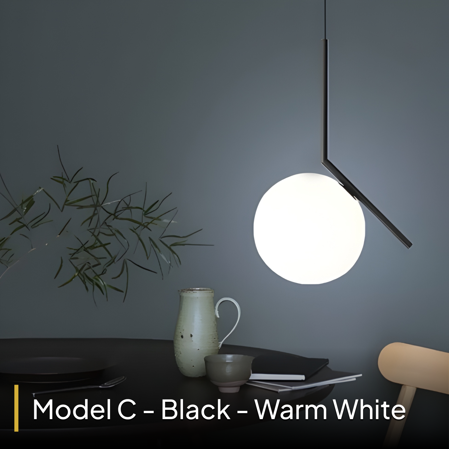Modern pendant light with a white bulb on a dark gray wall, next to a plant and decorative items.