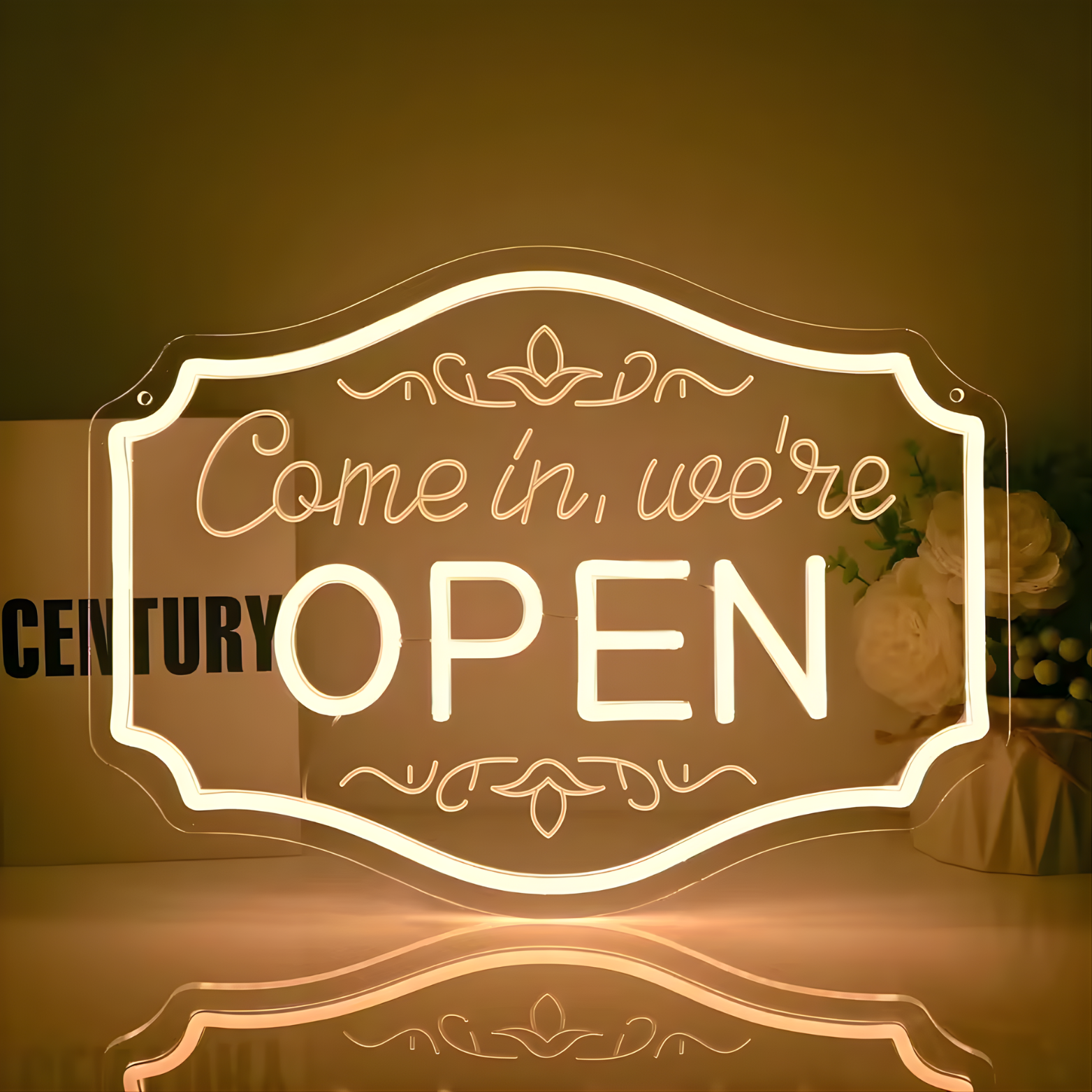 Neon sign with 'Come in, we're open' text on a reflective surface.